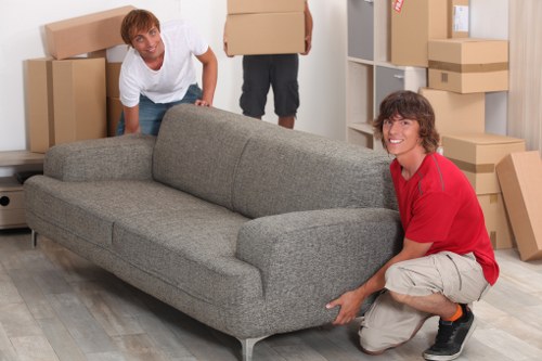 Removal team carrying household items through a Streatham property